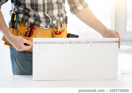 Worker measuring furniture board with tape Worker measuring furniture board with tape 106576600