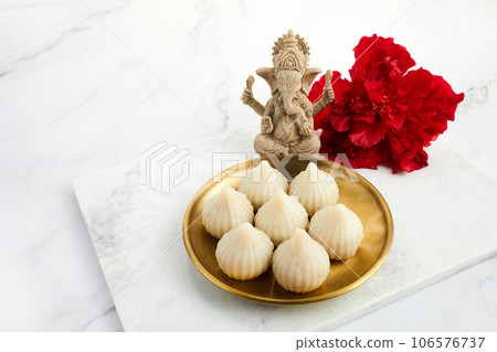 Idol of lord Ganesha with Modak Sweet Dish and flower. Ganesh chaturthi Idol of lord Ganesha with Modak Sweet Dish and flower. Ganesh chaturthi 106576737