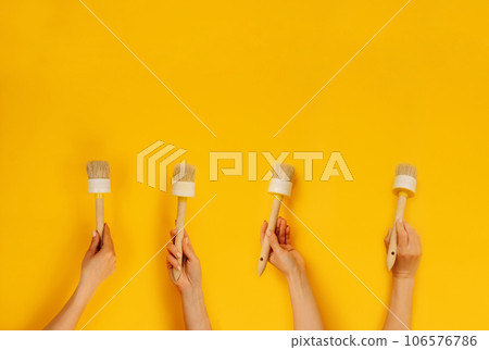 Hands holding paint brush 106576786