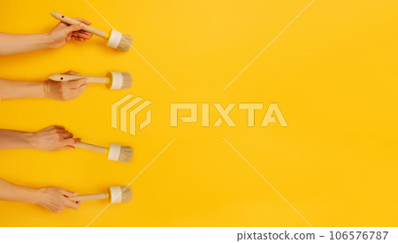 Hands holding paint brush 106576787