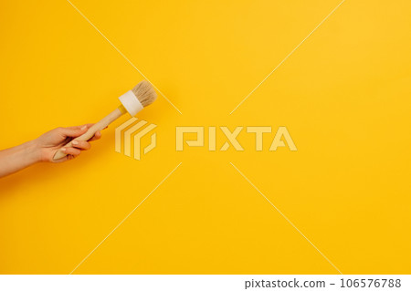 Hand holding paint brush 106576788