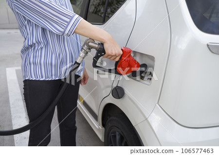 Man refueling car at petrol station Man refueling car at petrol station 106577463