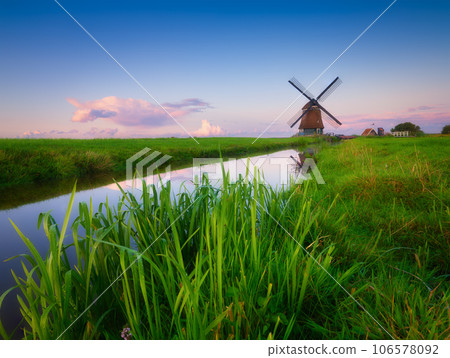 An old mill in the Netherlands. Historical building. A mill near a canal. An old mill in the Netherlands. Historical building. A mill near a canal. 106578092