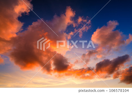 Pink clouds during sunset. Blue sky. Sunshine. A huge clouds in the sky after a storm. 106578104