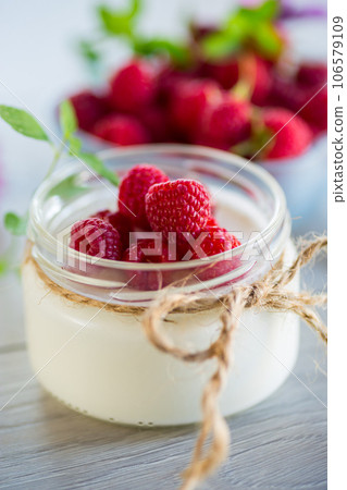 Sweet cooked homemade yogurt with fresh raspberries in a glass jar. 106579109
