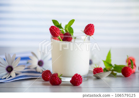 Sweet cooked homemade yogurt with fresh raspberries in a glass. Sweet cooked homemade yogurt with fresh raspberries in a glass. 106579125