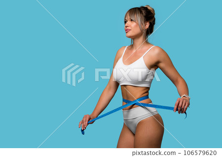 Slim woman in white underwear measure waist with tape Slim woman in white underwear measure waist with tape 106579620