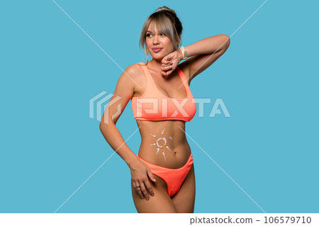 Woman with sunscreen on tanned belly in form of sun Woman with sunscreen on tanned belly in form of sun 106579710