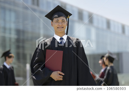 一名男學生穿著學士服看著鏡頭的畢業典禮照片 106580303