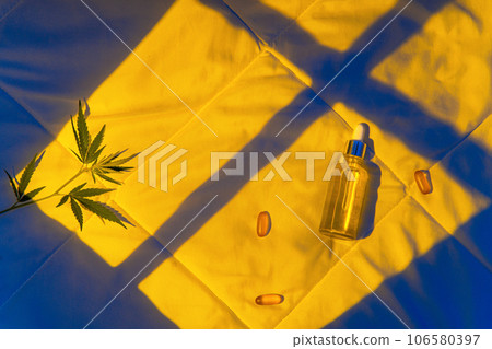 Night bedroom, a bottle of cannabis oil, cannabis branch in moonlight 106580397