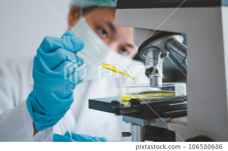 Female researchers are experimenting with pipette dropping a sample into a test tube in an experiment research in laboratory... Female researchers are experimenting with pipette dropping a sample into a test tube in an experiment research in laboratory... 106580686