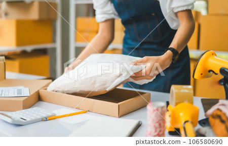 Online small business owners are packing their ordered products that customers order online into a box .concept of online shopping 106580690