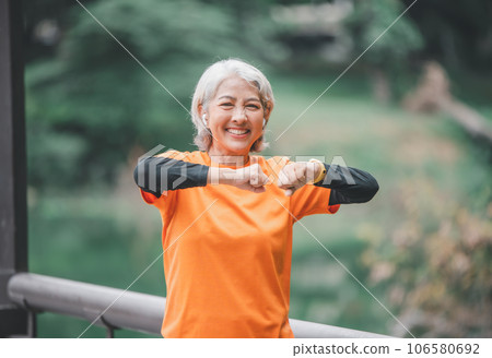 white-haired elderly person exercising in the park early in the morning. white-haired elderly person exercising in the park early in the morning. 106580692