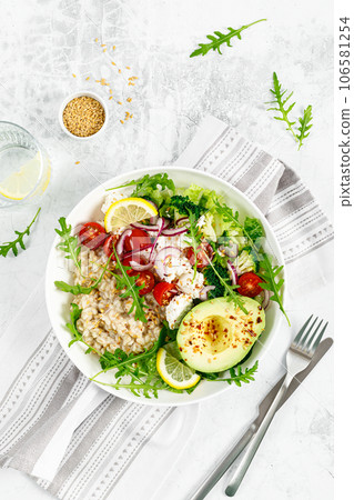 Oatmeal porridge with avocado, cottage cheese, tomatoes, fresh green salad and arugula. Healthy breakfast. Top view Oatmeal porridge with avocado, cottage cheese, tomatoes, fresh green salad and arugula. Healthy breakfast. Top view 106581254