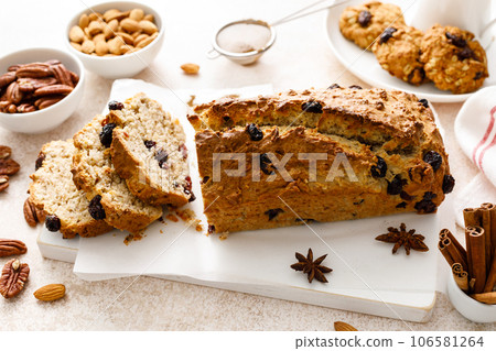 Fruitcake with cranberry, almond and pecan nuts sliced on a wooden board 106581264