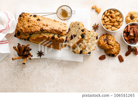 Fruitcake with cranberry, almond and pecan nuts sliced on a wooden board 106581265