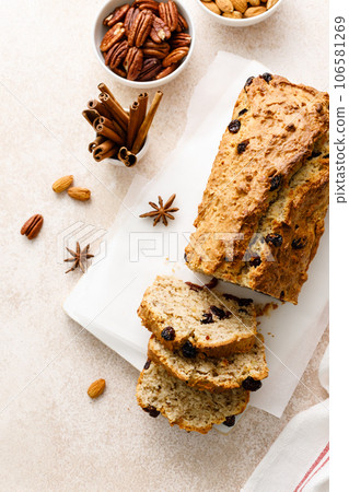 Fruitcake with cranberry, almond and pecan nuts sliced on a wooden board Fruitcake with cranberry, almond and pecan nuts sliced on a wooden board 106581269