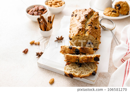 Fruitcake with cranberry, almond and pecan nuts sliced on a wooden board Fruitcake with cranberry, almond and pecan nuts sliced on a wooden board 106581270