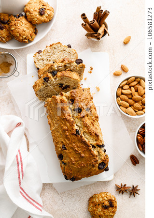 Fruitcake with cranberry, almond and pecan nuts sliced on a wooden board 106581273