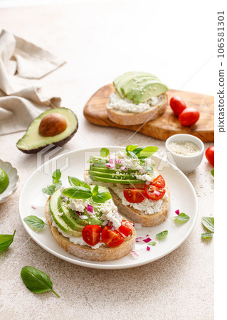 Avocado toast with cheese cottage, tomato and herbs for breakfast Avocado toast with cheese cottage, tomato and herbs for breakfast 106581301