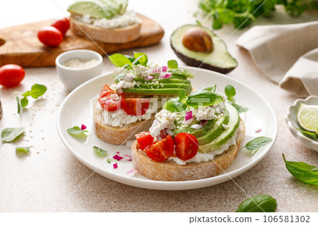 Avocado toast with cheese cottage, tomato and herbs for breakfast Avocado toast with cheese cottage, tomato and herbs for breakfast 106581302