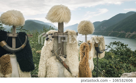 Georgian papakhas are sold to tourists against the backdrop of mountains. Journey along the military Georgian road. Georgian papakhas are sold to tourists against the backdrop of mountains. Journey along the military Georgian road. 106582606