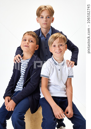 Boys, children, classmates in stylish school uniform against white studio background. Friendship 106582745