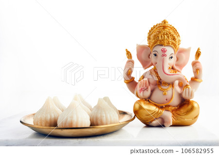 Idol of lord Ganesha with Modak Sweet Dish and flower. Ganesh chaturthi Idol of lord Ganesha with Modak Sweet Dish and flower. Ganesh chaturthi 106582955