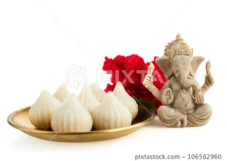 Idol of lord Ganesha with Modak Sweet Dish and flower. Ganesh chaturthi 106582960