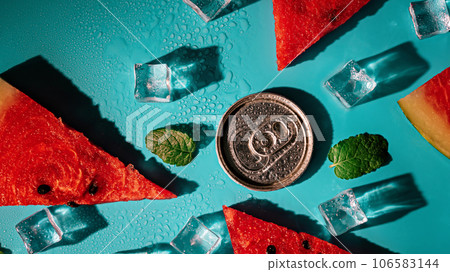 Creative summer composition with watermelon, mint leaves, can of soda and ice cubes. Minimal watermelon drink concept. Creative summer composition with watermelon, mint leaves, can of soda and ice cubes. Minimal watermelon drink concept. 106583144
