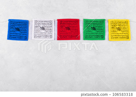 Colorful Tibetan buddhist prayer flags by Nepal on a grey background, copy space Colorful Tibetan buddhist prayer flags by Nepal on a grey background, copy space 106583318