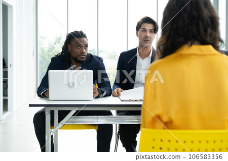 Job interview concept. Diverse hr team doing job interview with a woman in business office. Human resources team interviewing a potential job candidate. Hiring, employment, and recruitment concept. 106583356