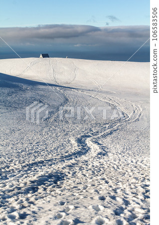Footprints in snowy landscape at Fimmvoerduhals hiking trail in early morning 106583506