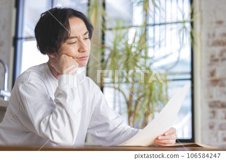 A man troubled watching a document 106584247