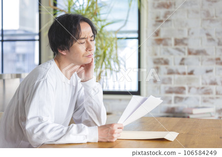 A man troubled watching a document A man troubled watching a document 106584249