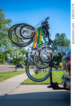 vertical mounted bikes on a vehicle carrier attached to a trailer hitch.  106585176