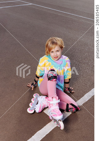 A beautiful little girl learns to roller skate  106585485