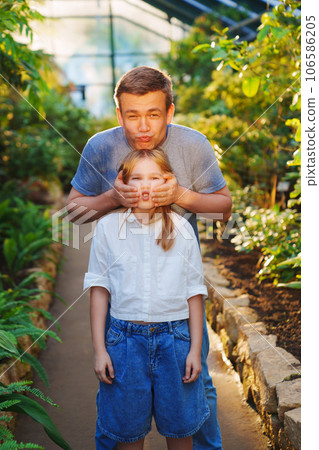 funny Dad and daughter are a teenager on a walk in the botanical garden. 106586205