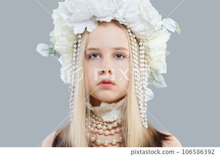 Attractive young girl in pearls and white flower hat on grey background 106586392