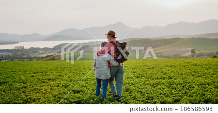 Senior couple standing in the middle of meadow and having romantic moment at the autumn nature. 106586593