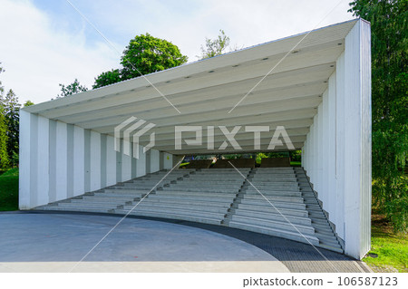 Empty open air stage in a park, with a sound projecting roof and walls on a sunny summer day 106587123