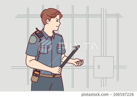 Man prison guard with rubber club in hand walks near cell for criminals and keeps order in jail Man prison guard with rubber club in hand walks near cell for criminals and keeps order in jail 106587226