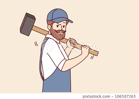 Bearded man with hammer works at construction site, dressed in overalls with cap 106587263