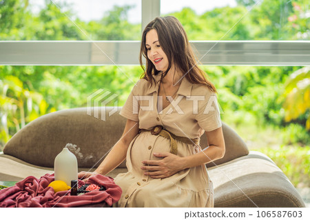 A serene moment captured as a pregnant woman after 40 embraces the soothing benefits of aroma oils and an aroma diffuser, enhancing her pregnancy journey with relaxation and tranquility 106587603
