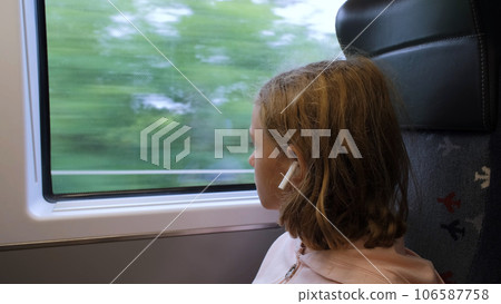 Little girl looking through a window in Mass Rapid Transit train. Public transport concept 106587758