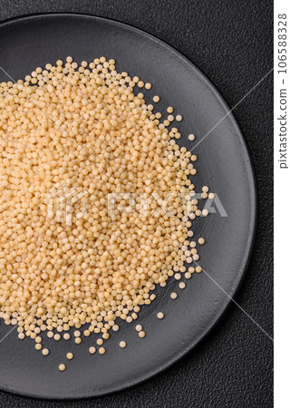 Raw ptitim pasta in a ceramic bowl on a dark concrete background Raw ptitim pasta in a ceramic bowl on a dark concrete background 106588328