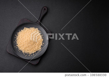 Raw ptitim pasta in a ceramic bowl on a dark concrete background Raw ptitim pasta in a ceramic bowl on a dark concrete background 106588330
