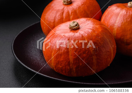 Beautiful fresh round pumpkins in orange color on a dark concrete background 106588336
