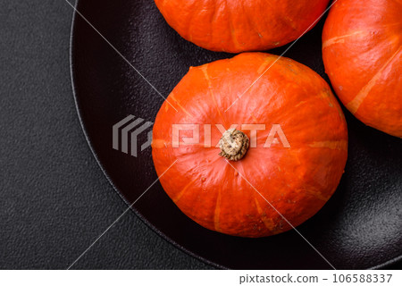 Beautiful fresh round pumpkins in orange color on a dark concrete background 106588337