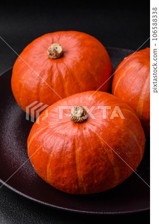 Beautiful fresh round pumpkins in orange color on a dark concrete background 106588338